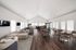 Spacious, modern community lounge with elegant wooden flooring, comfortable seating areas, and abundant natural light from large windows.