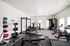 Bright and inviting fitness center with modern equipment, featuring treadmills, exercise bikes, weights, and strength machines for a complete workout experience.