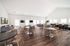 Expansive open-concept living area with modern sofas, sleek dining tables, and a stylish bar counter, perfect for entertaining.