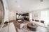 Modern open-concept living room and kitchen with chic furniture, sleek cabinetry, and natural light.