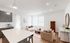Bright and modern living room with open-concept design, featuring chic white sofas, a stylish coffee table, and elegant wood accents.