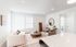 Bright and inviting living room with modern decor, featuring a cozy beige sofa, elegant coffee table, and plush armchair in a stylish, open-concept apartment.