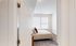 Inviting bedroom with natural light, cozy bedding, and elegant minimalistic design.