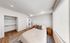 Bright and airy bedroom with elegant wood flooring, sleek open closet, and abundant natural light creating a serene retreat.
