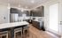 Modern kitchen with sleek cabinetry, stainless steel appliances, and a chic center island with seating, offering a stylish and functional space.