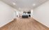Spacious open-plan living area with modern kitchen, featuring sleek cabinetry and elegant wood flooring.
