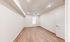 Bright, modern room with sleek wooden flooring and recessed lighting, perfect for versatile living in a contemporary apartment.
