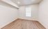 Inviting room with elegant hardwood floors and a large window, offering a blank canvas for personalization.
