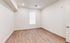 Inviting and spacious blank room with elegant wood flooring and bright natural light, perfect for customization.