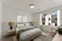 Bright, modern bedroom with elegant neutral tones, large window, and stylish decor for a serene retreat.