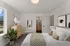 Bright and inviting bedroom with modern decor, featuring a cozy bed, stylish artwork, and a scenic window view.