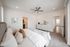 Elegant bedroom with a cozy king-size bed, stylish dresser, contemporary ceiling fan, and soothing neutral decor.