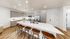 Elegant kitchen with modern appliances, white countertops, and cozy wooden bar stools, offering a perfect blend of style and functionality.