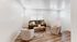Chic and cozy living room with elegant sofa, plush chairs, and natural wood flooring, bathed in abundant natural light.