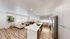 Modern open-concept kitchen and living area with sleek appliances, cozy seating, and elegant wood flooring.