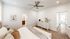 Bright and inviting bedroom with elegant decor and modern ceiling fan, connected to a well-appointed bathroom.