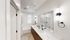 Luxurious modern bathroom with dual sinks, large mirror, and glass-enclosed shower, accented by sleek black fixtures and elegant lighting.