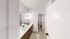Elegant modern bathroom with sleek vanity, spacious mirror, and stylish lighting, creating a bright and inviting space.