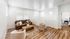 Bright and airy living room featuring modern furniture, warm wood flooring, and natural light streaming through multiple windows.