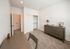 Bright and cozy room with plush carpet, modern gray furniture, and ample closet space offering a serene retreat.