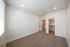 Spacious and modern bedroom with plush carpeting, abundant natural light, and a roomy walk-in closet.