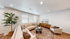 Inviting modern living room featuring a cozy beige sofa, plush armchair, elegant coffee table with decor, and a large window for natural light.