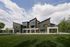 Contemporary apartment complex with unique architectural design, surrounded by lush greenery and spacious lawns.