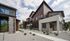 Modern townhouses with sleek architectural design and landscaped surroundings, featuring vibrant siding and large windows.