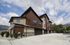 Modern multi-story townhouse with sleek design, large windows, and mountain backdrop, perfect for contemporary living.