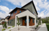 Modern townhome with contemporary architectural design, featuring a stylish exterior, vibrant colors, and lush landscaping under a bright blue sky.