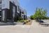 Modern apartment complex with elegant design, lush landscaping, and convenient street access, ideal for urban living.