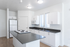 Modern kitchen with sleek white cabinets, a spacious island, and ample natural light.