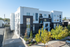 Modern apartment building with stylish architecture, surrounded by lush trees and offering bright, spacious living spaces for rent.