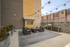 Chic urban patio featuring cozy wicker seating, modern grill, and stylish string lights for outdoor relaxation.