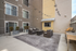 Chic outdoor patio with comfortable seating, beautiful string lights, and a modern grill, perfect for entertaining guests.