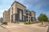 Modern apartment building with sleek design, lush landscaping, and ample parking in a vibrant neighborhood.