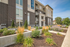 Modern apartment building exterior with lush landscaping and inviting entrance, offering a glimpse of contemporary urban living.