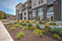 Modern apartment complex with sleek architecture, abundant greenery, and vibrant landscaping for a welcoming entrance.
