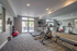 Bright and modern gym with cardio machines and weights, featuring large mirrors and natural lighting.