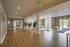 Elegant apartment lobby with wooden floors, stylish decor, and ample natural light from large windows.