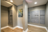 Contemporary apartment mailroom with sleek gray mailbox units, polished wood flooring, and modern artwork.