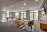 Bright and spacious living room with elegant furnishings, large windows, pool table, and modern decor.