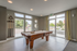 Elegant recreation room with large windows, featuring a premium billiards table and scenic outdoor views.