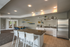 Modern open-concept kitchen and dining area with sleek stainless steel appliances, stylish bar seating, and contemporary decor.