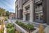 Modern apartment complex entrance with sleek design, lush landscaping, and welcoming seating areas.