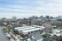 Charming urban neighborhood with modern townhouses and a stunning city skyline backdrop, perfect for vibrant city living.