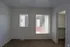 Bright bedroom with natural light from large windows, showcasing modern blinds and a spacious closet.