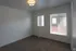 Bright and cozy bedroom with plush carpet and modern lighting, featuring large windows for ample natural light.