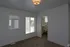 Bright bedroom with plush carpeting and large windows, featuring a convenient walk-in closet and a stylish ceiling light.