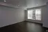 Bright and spacious room with elegant dark wood flooring and large window blinds, creating a modern and inviting atmosphere.